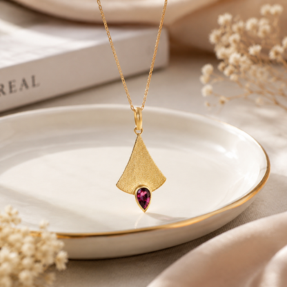 Pendentif en or avec pierre précieuse rose.