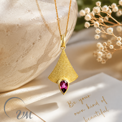 Pendentif en or avec pierre précieuse rose.